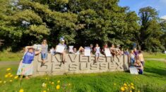 Striking workers by a sign for the University of Sussex