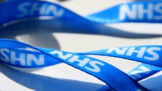 A blue lanyard that says NHS